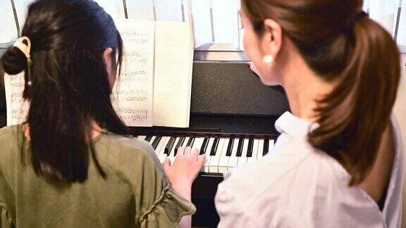 母亲和女儿在弹钢琴