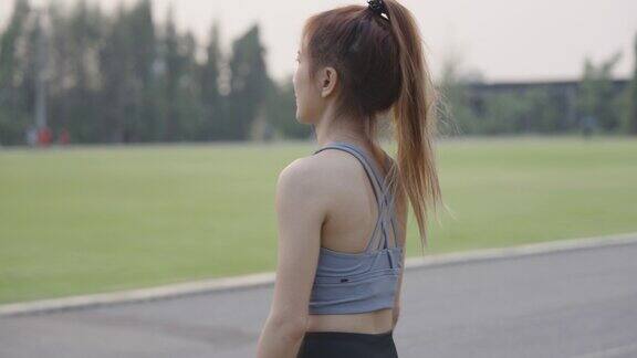 一名亚洲女子准备在田径场锻炼