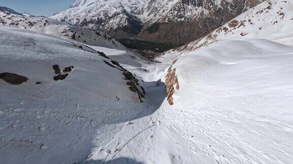 FPV运动无人机潜水山峡谷冬季阳光明媚景观冰川滑雪者