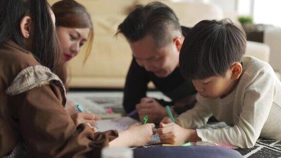 一个年轻的亚洲华人家庭在周末的时候在家里的客厅公寓里画画