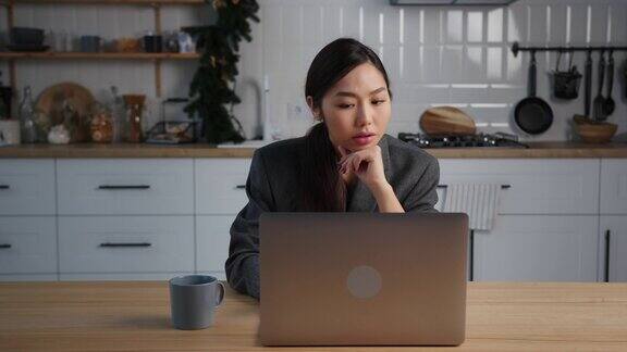 亚洲女商人在假期晚上使用笔记本电脑在家工作
