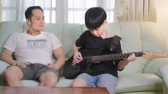 父亲在客厅听儿子弹电吉他