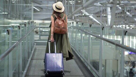 亚洲女子少年行走和寻找信息在机场航站楼-背包旅行在假期夏天年轻迷人的亚洲女子乘客