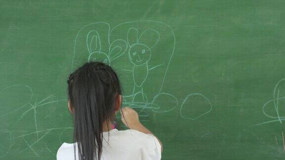 小女孩在家里用黑板画画