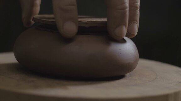 工匠在宜兴陶壶上试盖为中国茶道制作的手工陶壶褐色陶器茶壶4k的视频59.94帧秒