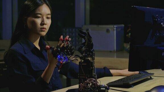 年轻的电子开发工程师在实验室测试创新机器人技术年轻的亚洲女性为机械机械手创造运动有技术或创新观念的人
