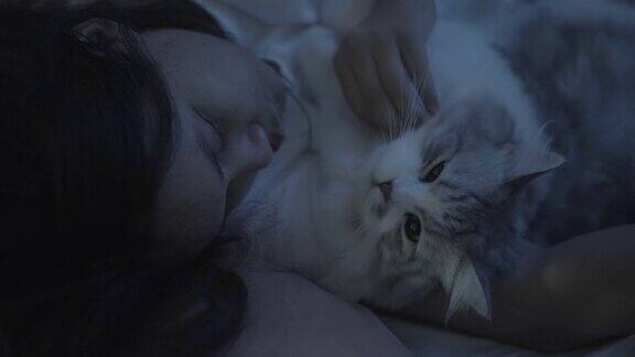 年轻女人和她的猫睡在床上
