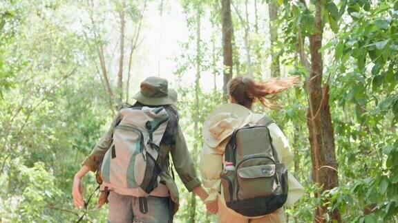 亚洲美丽的两个女人背包旅行在森林野生一起迷人的年轻女性朋友们在夏天的假期旅行期间散步和探索自然树林的快乐