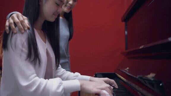 亚洲女音乐导师和她的学龄前女学生一起工作