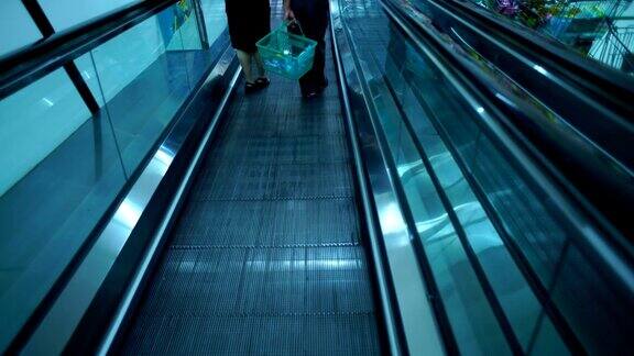 人们在购物中心的自动扶梯上走动