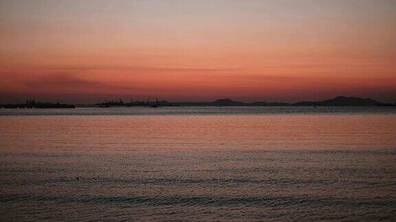 红色日落在海上视频4K太阳落到地平线上红色的天空黄色的太阳和惊人的海洋夏日夕阳海景泰国海洋海滩日落太阳在旋转的云奇妙的自然日落