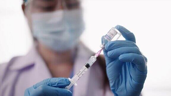 特写医生拿着一个注射器填充疫苗