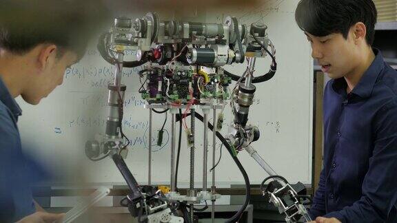 年轻的电子工程师团队在车间协作建造机器人团队工程师一起启动机器人项目有技术或创新观念的人