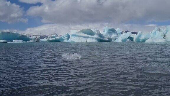 冰山和冰块在寒冷的海水中冰川在温暖的阳光下融化