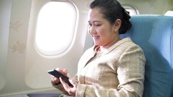 亚洲女性在飞机上使用智能手机