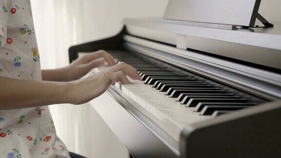 4K:亚洲女孩弹钢琴的慢镜头