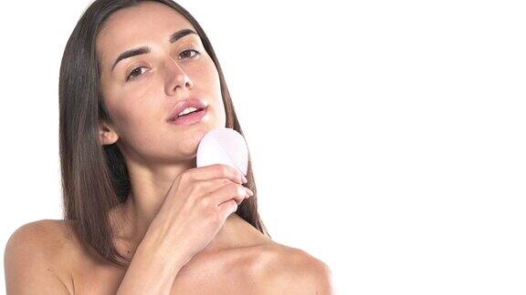 年轻女子用化妆刷清洁按摩护肤概念孤立在白色背景上