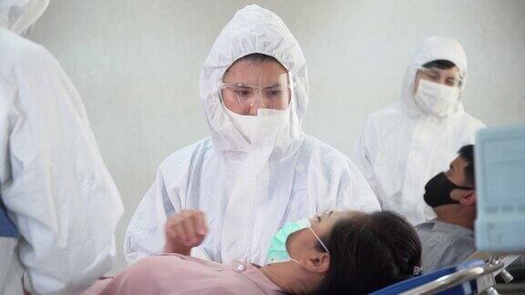 一群身穿防护服的亚洲医生正在医院隔离病房的病床上检查和治疗因冠状病毒或covid-19咳嗽的患者流感爆发