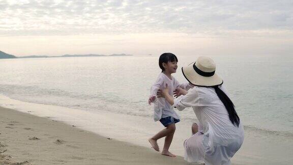 亚洲母亲和女儿享受假期的海滩在晚上