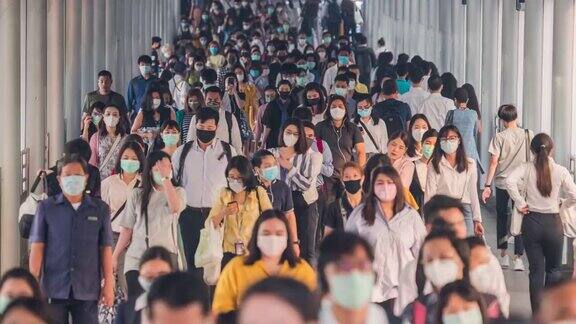 在早高峰时间亚洲人在曼谷上班时戴着预防冠状病毒或新冠病毒的面罩和空气中的微尘pm2.5