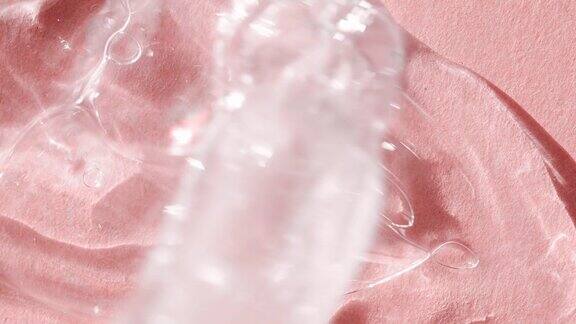 透明的身体血清在粉红色的背景顶部视图化妆品滴管与液体肥皂洗发水的特写