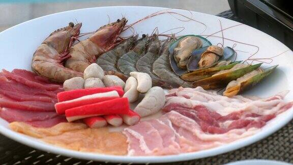 搭配海鲜、猪肉片和牛肉片的盘子适合寿喜烧、烧烤或涮锅