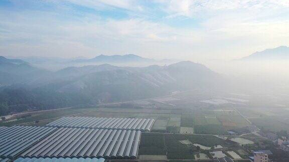 在晨雾中鸟瞰农田和太阳能发电站