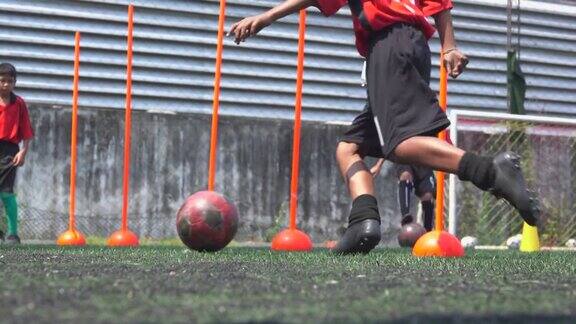 男孩足球运动员练习踢足球