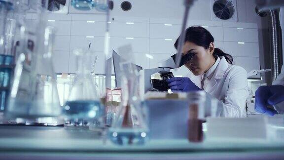 未来实验室内部亚洲女医生使用显微镜