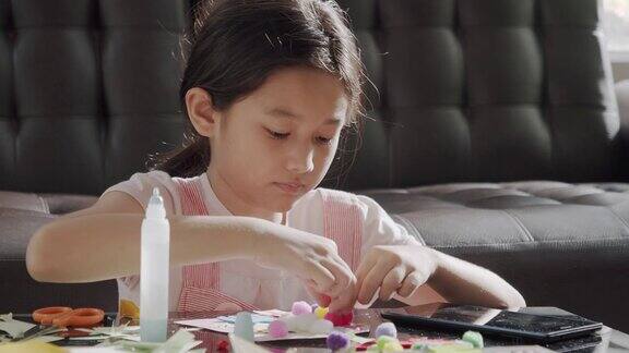 亚洲女孩在家剪纸和做她的艺术和手工艺品他们用彩纸、剪刀和胶水在纸上创造艺术项目形成她的想象艺术和工艺概念