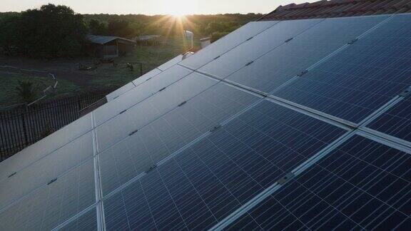 日出时屋顶上的太阳能电池板的空中特写