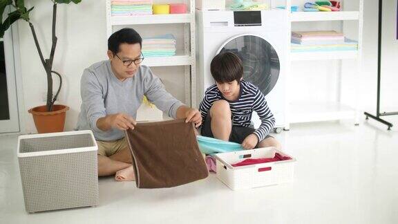 亚洲父亲和他的儿子在家里一起洗衣服家庭家务在一起