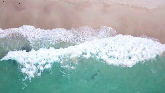 鸟瞰图热带海滩和波浪与白色的沙滩和蓝色的大海