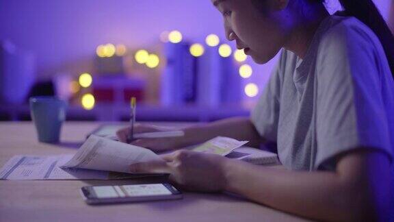年轻的中国女性晚上在家支付网上账单做预算