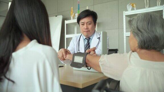男医生在给病人量血压医院里的女长者