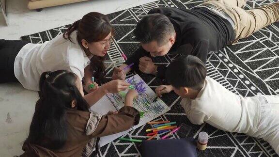 正上方的亚洲华人年轻家庭享受亲情时光周末在家里的客厅公寓画画