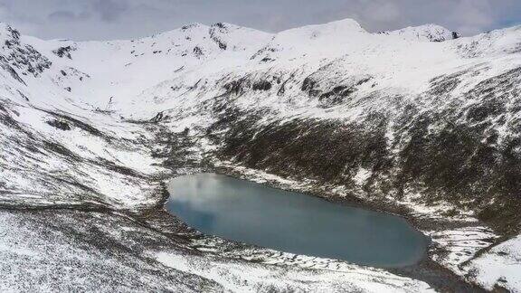 在一个阴天蓝色的湖躺在雪山的怀抱