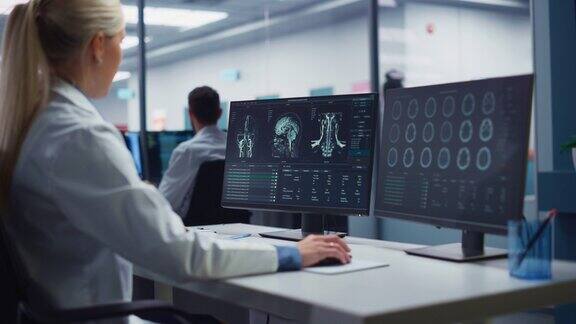 医院研究实验室:女性医学科学家使用计算机与脑部MRI扫描图像寻找治疗专业神经学家分析CT扫描为病人寻找治疗方法在肩膀上