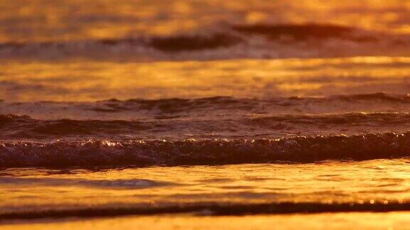 4K近距离的海滩和波浪在日落