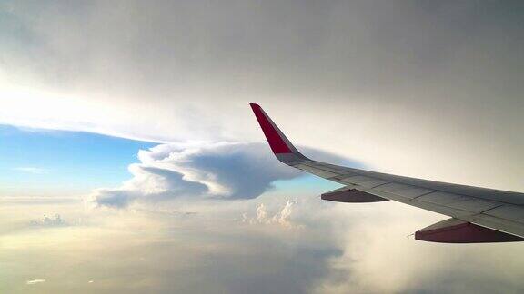 4K镜头的飞机飞过奇妙的云和天空在日落时间