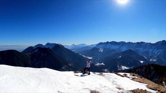 从奥地利卡林西亚卡拉万克斯雪峰的FerlacherHorn上看风景的女人泽尔普法尔山谷中的一个山村观弗赖堡朱利安阿尔卑斯山阳光明媚的冬日