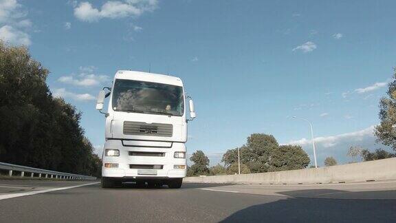 带货运拖车的货车在高速公路上行驶白色卡车在清晨运送货物