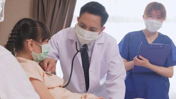 医生在康复室的床上用听诊器测量小孩的心率