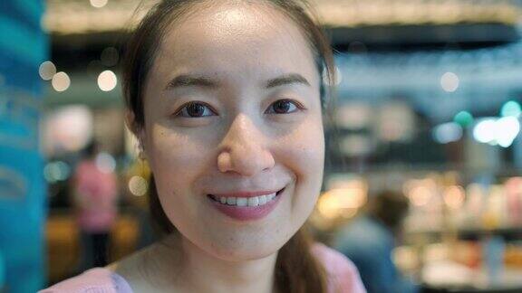 周末一名亚洲女性在咖啡馆对着镜头微笑