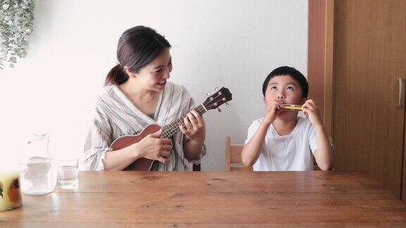 母亲和儿子在家里演奏音乐