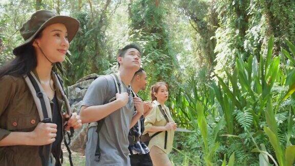 一群亚洲背包客在森林里玩得很开心迷人的男人和女人的朋友旅行散步和探索自然木材与快乐在暑假假期旅行