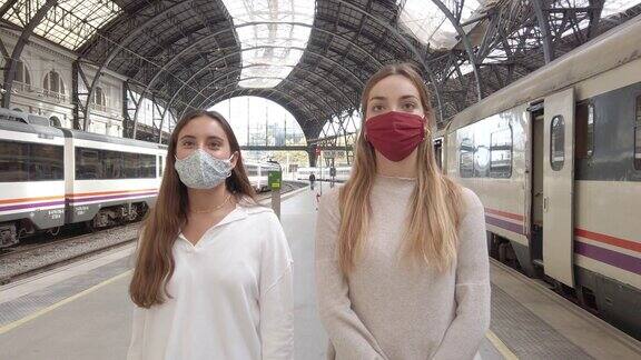 戴着防护口罩的妇女在火车站经过火车