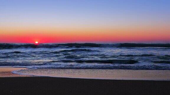 燃烧着日出的天空海浪拍打着海滩