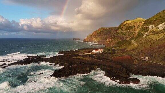 葡萄牙亚速尔群岛的圣米格尔岛最西端的角蓬塔达法拉利亚的鸟瞰图棕色的岩石大西洋和彩虹的天空