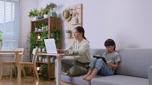 母亲和儿子在客厅工作和学习